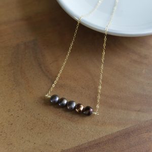 5 dark pearls on a gold chain necklace