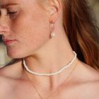 white beaded choker, pearl hoops, pearl pendant necklace on a fair skinned girl