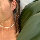 small gold hoops, diamond earrings, white beaded choker on a girl with fishtail braids